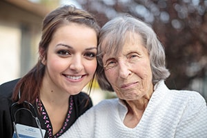 A nurse smiling with an elderly woman