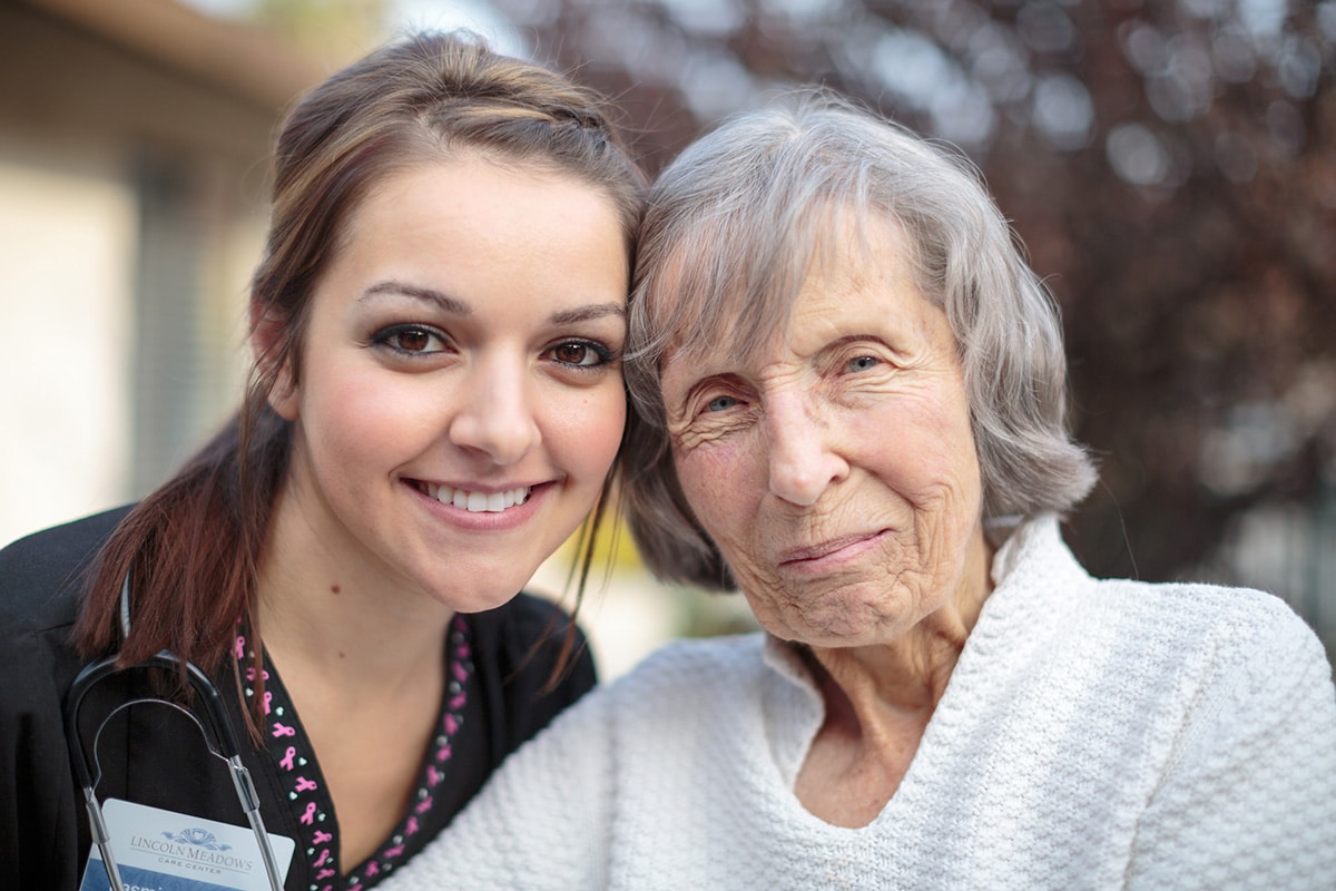 A nurse smiling with an elderly woman at Lincoln Meadows