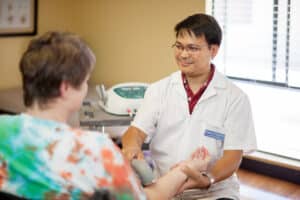 A nurse helping an elderly woman at Lincoln Meadows